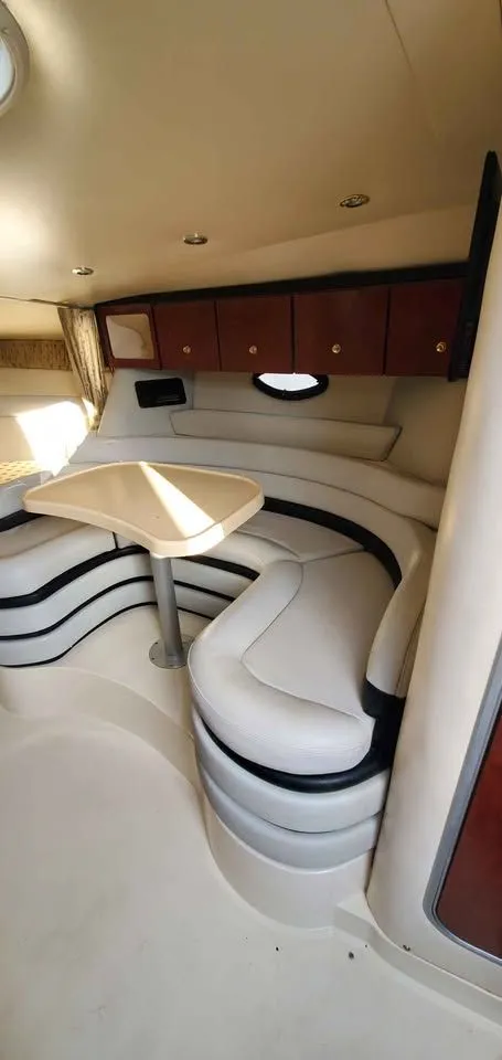 Slide: The Image of Interior of the 2002 Wellcraft 3300 Martinique with curved seating area and table. - 16