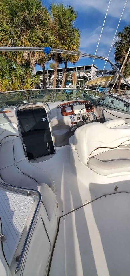 Slide: The Image of The image shows the cockpit of a 2002 Wellcraft 3300 Martinique with white seating and palm trees in the background. - 6