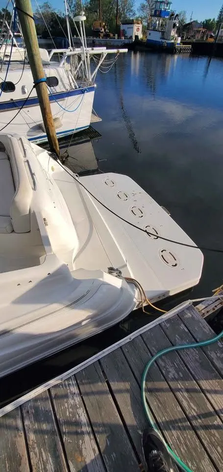 Slide: The Image of A 2002 Wellcraft 3300 Martinique is docked. The boat features a spacious deck. - 5