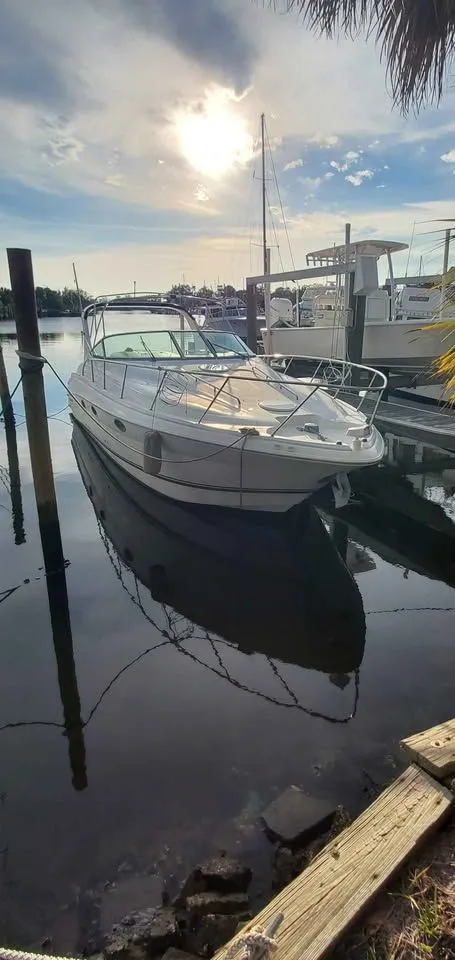 Slide: The Image of A 2002 Wellcraft 3300 Martinique is docked in the water on a sunny day at the marina. - 2