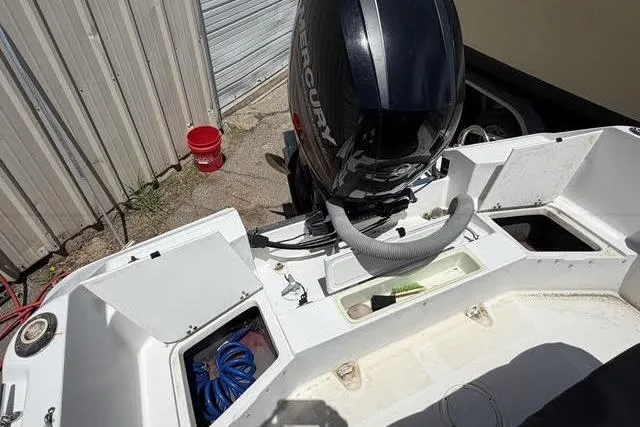 Slide: The Image of 2000 Robalo 1820 Center Console boat with Mercury outboard motor, docked near a metal building. - 10