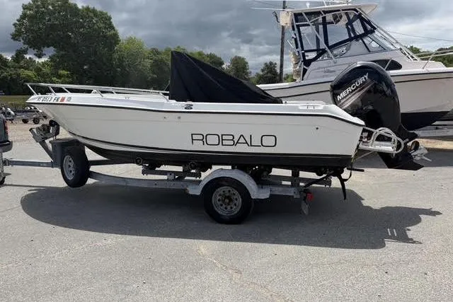 The Image of 2000 Robalo 1820 Center Console boat on trailer, parked outdoors. - 1