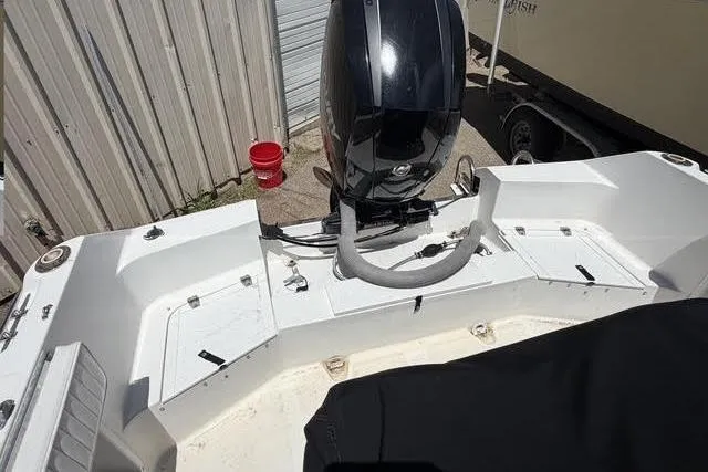 Slide: The Image of 2000 Robalo 1820 Center Console boat with outboard motor, docked near metal siding. - 9