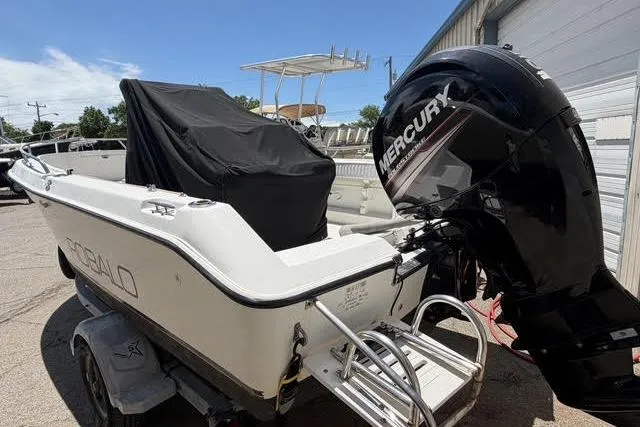 Slide: The Image of 2000 Robalo 1820 Center Console boat with Mercury outboard motor, parked outdoors. - 2