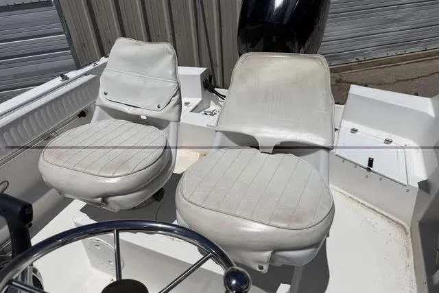 Slide: The Image of 2000 Robalo 1820 Center Console boat interior with dual white seats and steering wheel. - 18