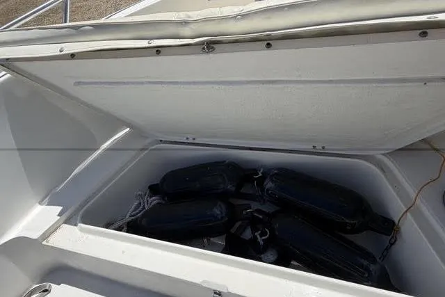 Slide: The Image of Open storage compartment on a 2000 Robalo 1820 Center Console boat with black fenders inside. - 8