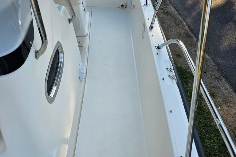 Slide: The Image of 2011 Boston Whaler 230 Dauntless boat deck with stainless steel railings and clean white surface. - 18