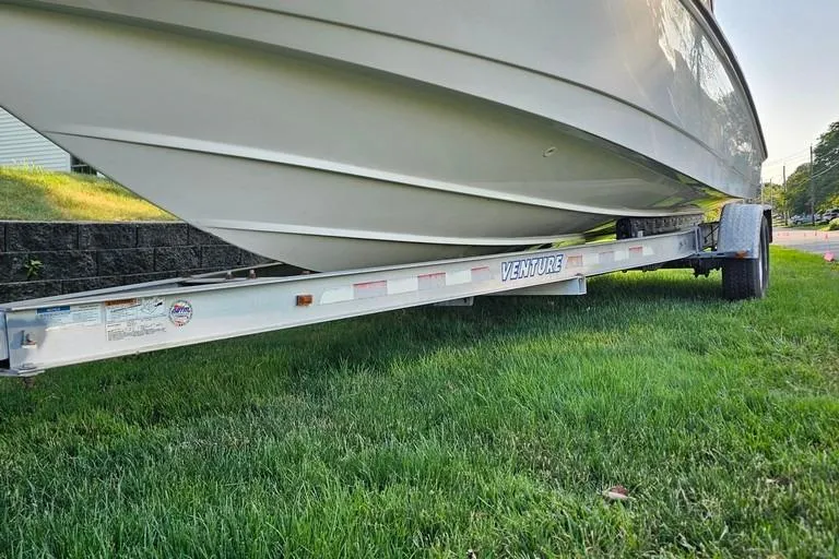 Slide: The Image of 2011 Boston Whaler 230 Dauntless boat on Venture trailer, parked on grass. - 3