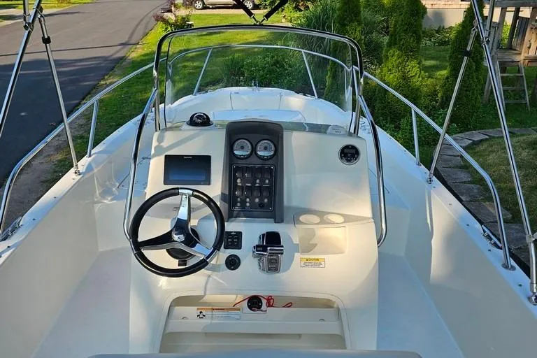 Slide: The Image of 2011 Boston Whaler 230 Dauntless boat cockpit with steering wheel and control panel. - 7
