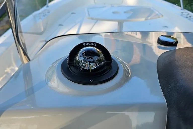 Slide: The Image of Compass on 2011 Boston Whaler 230 Dauntless boat dashboard, reflecting clear sky. - 9