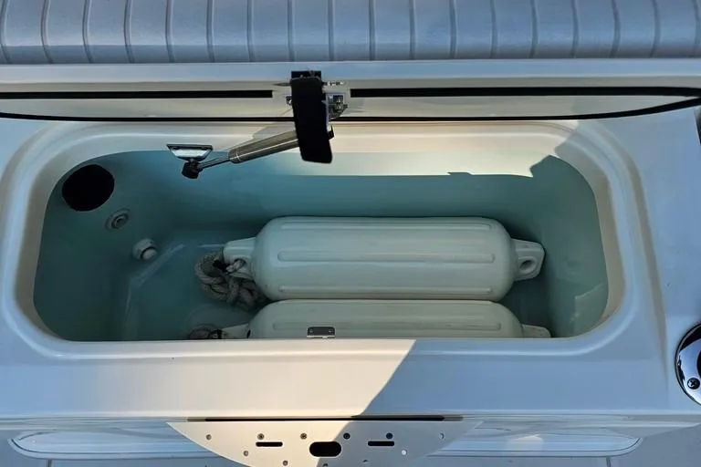 Slide: The Image of Livewell compartment on a 2011 Boston Whaler 230 Dauntless boat, featuring fenders and ropes. - 13