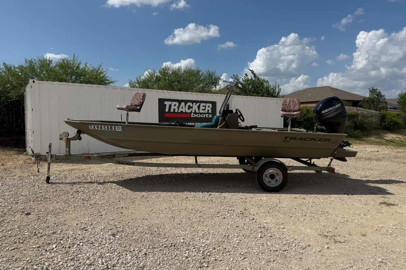 The Image of 2013 Tracker Grizzly 1860 CC boat on trailer, parked outdoors under a cloudy sky. - 1