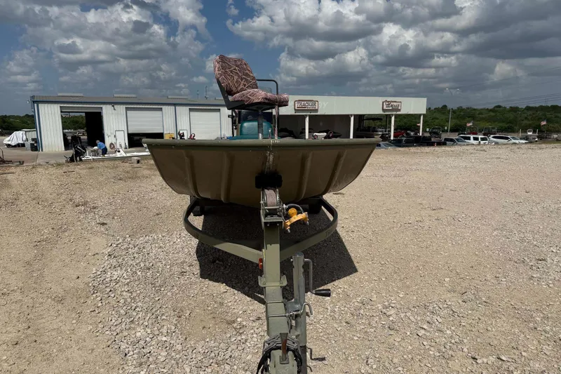 Slide: The Image of 2013 Tracker Grizzly 1860 CC boat on trailer at dealership under cloudy sky. - 6