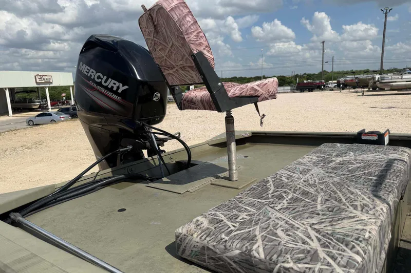 Slide: The Image of 2013 Tracker Grizzly 1860 CC boat with Mercury engine and camo seating, outdoors. - 7