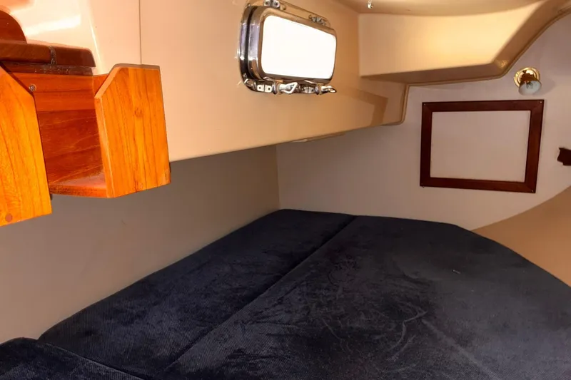 Slide: The Image of Cozy cabin interior of 1991 Island Packet 29 sailboat with wooden accents and porthole. - 30