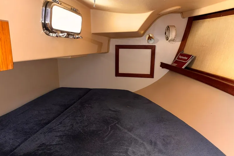 Slide: The Image of Cozy cabin interior of 1991 Island Packet 29 sailboat with bed and porthole. - 29