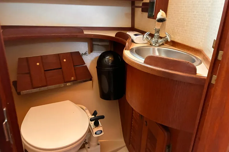 Slide: The Image of 1991 Island Packet 29 yacht bathroom with wooden cabinetry and compact sink. - 26