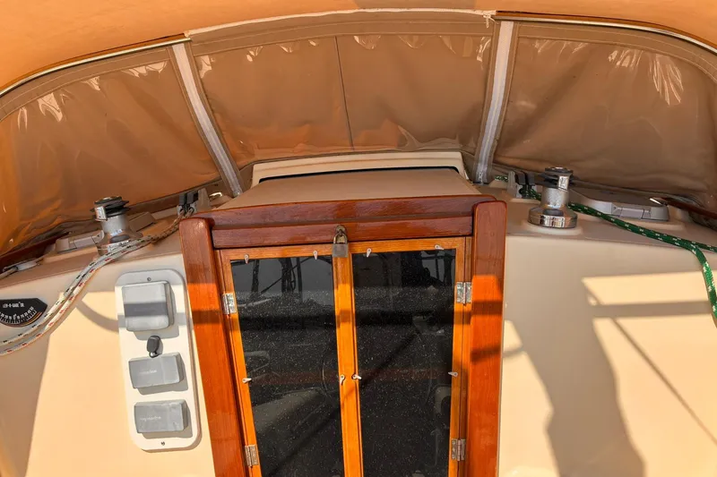 Slide: The Image of 1991 Island Packet 29 sailboat cockpit with wooden hatch and winches. - 3