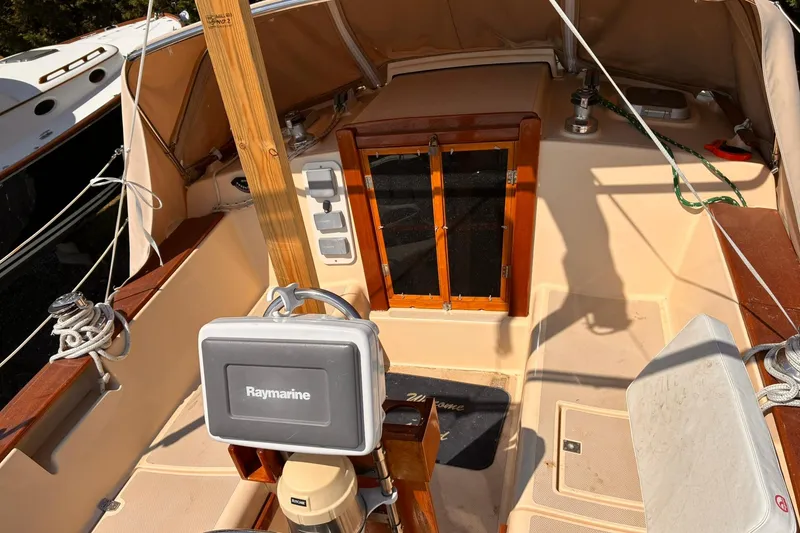 Slide: The Image of 1991 Island Packet 29 sailboat cockpit with Raymarine equipment and wooden hatch. - 5