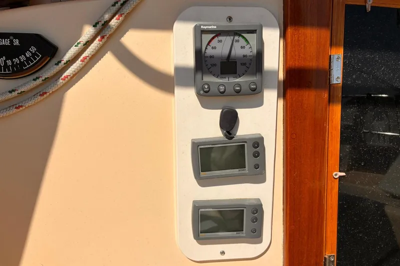 Slide: The Image of 1991 Island Packet 29 sailboat dashboard with Raymarine instruments and gauges. - 18
