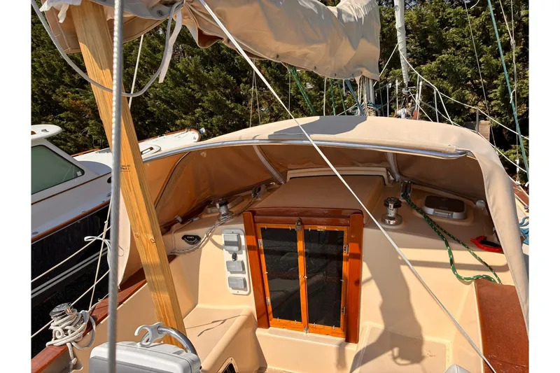 Slide: The Image of 1991 Island Packet 29 sailboat cockpit with tan canvas cover and wooden hatch. - 4