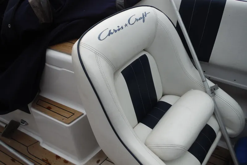 Slide: The Image of 2008 Chris-Craft Launch 25 boat seat with logo, featuring white and navy upholstery. - 14