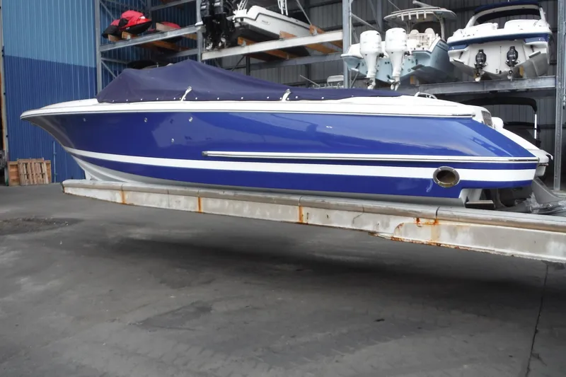 Slide: The Image of 2008 Chris-Craft Launch 25 boat in storage, blue hull with white accents, covered. - 3