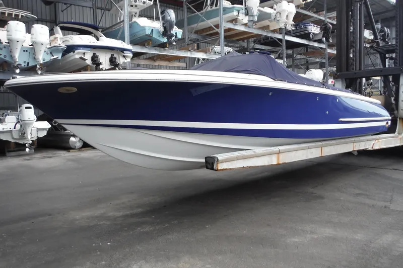 Slide: The Image of 2008 Chris-Craft Launch 25 boat in storage, featuring a sleek blue and white design. - 4