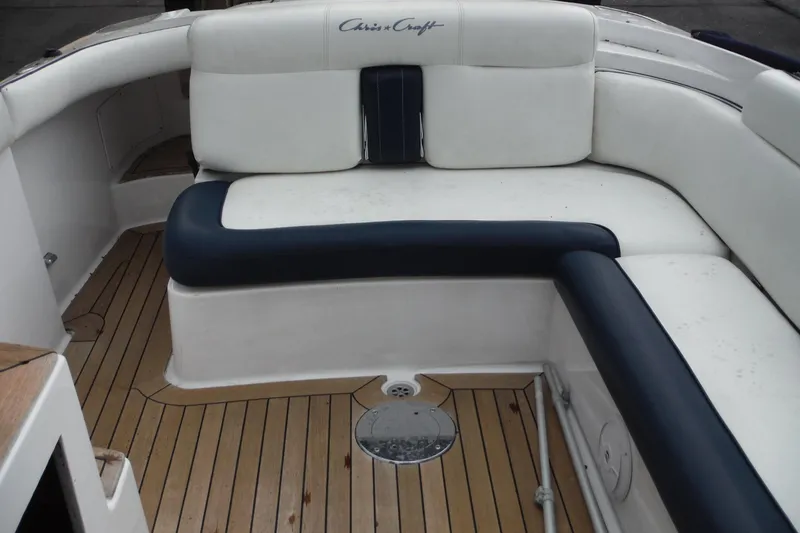 Slide: The Image of 2008 Chris-Craft Launch 25 boat interior with white and navy seating, teak flooring. - 8