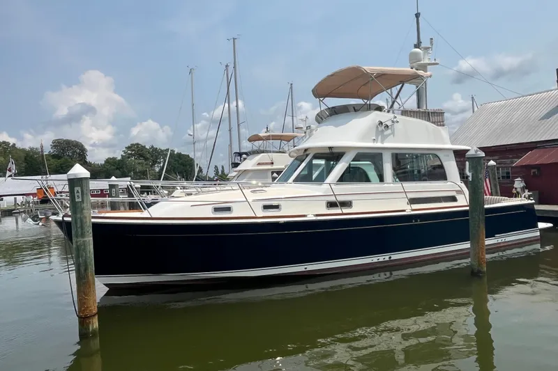 The Image of 2018 Sabre 42 Fly Bridge Sedan yacht docked at a marina under a clear sky. - 0