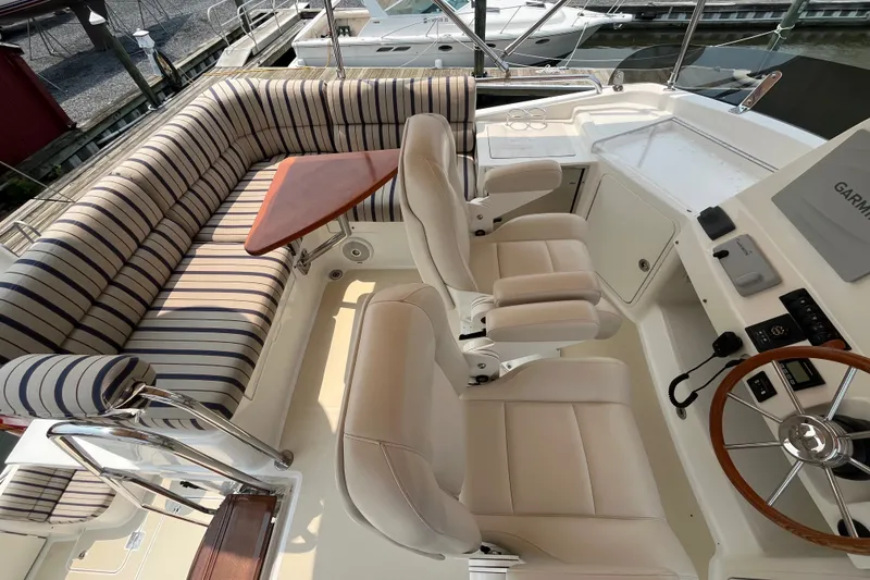 Slide: The Image of 2018 Sabre 42 Fly Bridge Sedan with striped seating and dual helm chairs. - 8