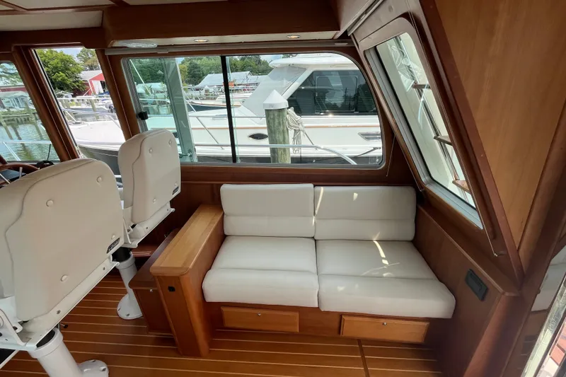 Slide: The Image of Interior of 2018 Sabre 42 Fly Bridge Sedan with white seating and wooden accents. - 20