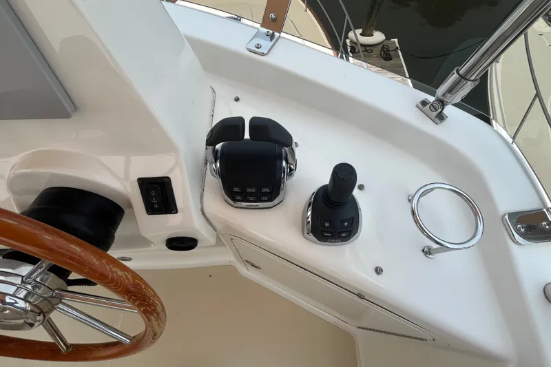 Slide: The Image of 2018 Sabre 42 Fly Bridge Sedan helm with controls and wooden steering wheel. - 11