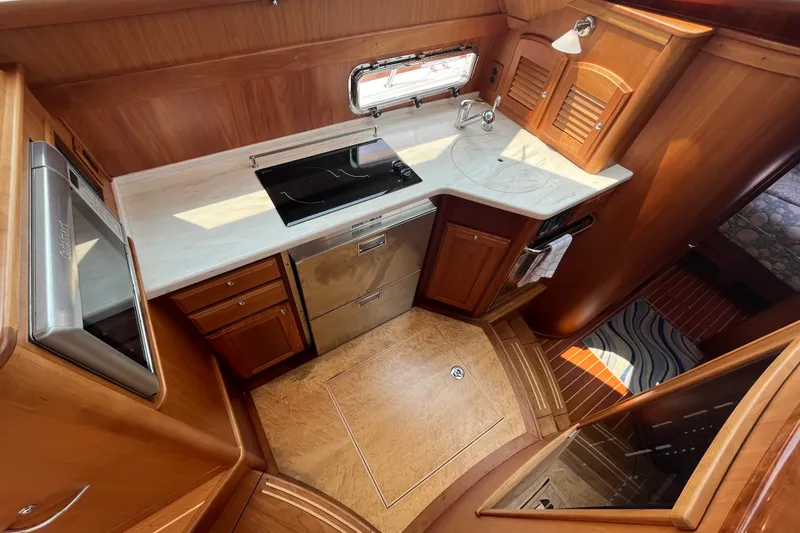 Slide: The Image of Luxurious galley in 2018 Sabre 42 Fly Bridge Sedan, featuring modern appliances and elegant wood finishes. - 25