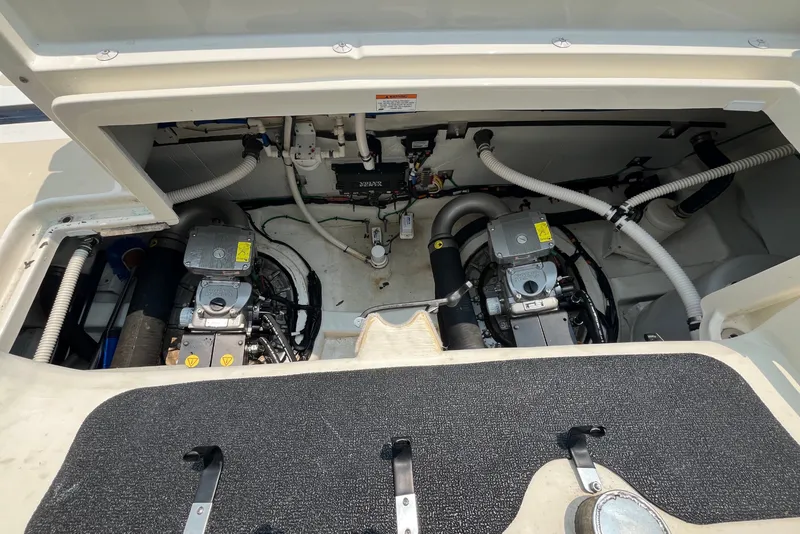 Slide: The Image of The engine compartment of a 2018 Sabre 42 Fly Bridge Sedan shows two engines and various hoses. - 48