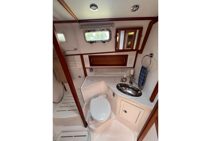 Slide: The Image of 2018 Sabre 42 Fly Bridge Sedan bathroom with sink, toilet, and wooden accents. - 31
