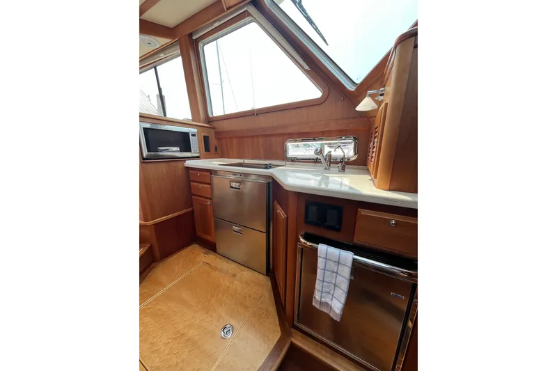 Slide: The Image of Interior of 2018 Sabre 42 Fly Bridge Sedan yacht kitchen with wood finish and stainless appliances. - 27