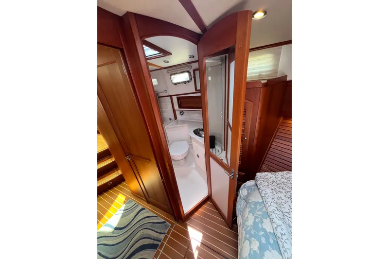 Slide: The Image of Interior of 2018 Sabre 42 Fly Bridge Sedan, featuring a compact bathroom with wooden accents. - 37