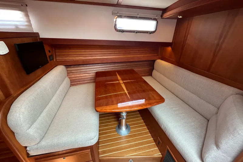 Slide: The Image of Interior of 2018 Sabre 42 Fly Bridge Sedan with wooden table and cushioned seating. - 28