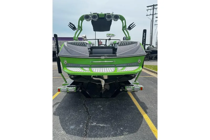 Slide: The Image of 2014 Nautique Super Air Nautique G21 boat, green exterior, rear view in parking lot. - 6