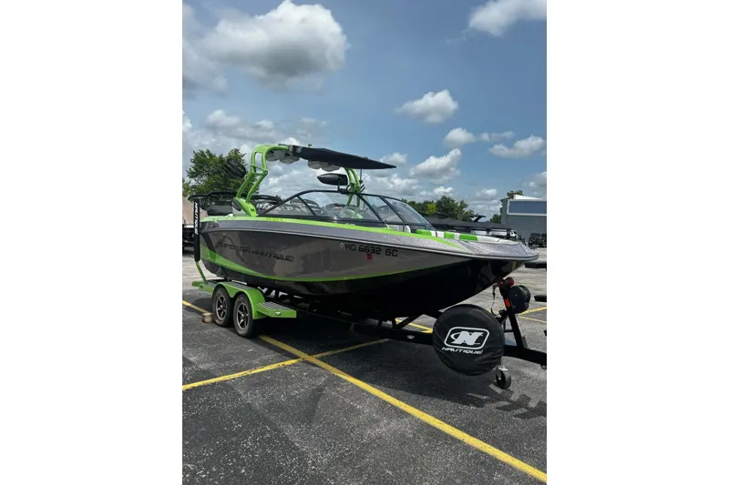 Slide: The Image of 2014 Nautique Super Air Nautique G21 boat on trailer, green and gray design. - 2