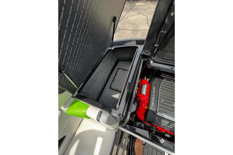 Slide: The Image of Open engine compartment of 2014 Nautique Super Air Nautique G21 boat, showcasing storage and engine details. - 21
