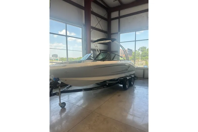 The Image of 2026 Chaparral 21 SSi boat on trailer in showroom, large windows in background. - 1
