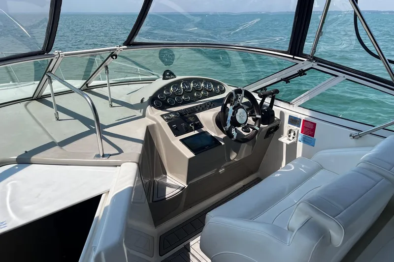 Slide: The Image of 2004 Cruisers Yachts 280 CXi Express helm with ocean view, featuring modern controls and seating. - 7