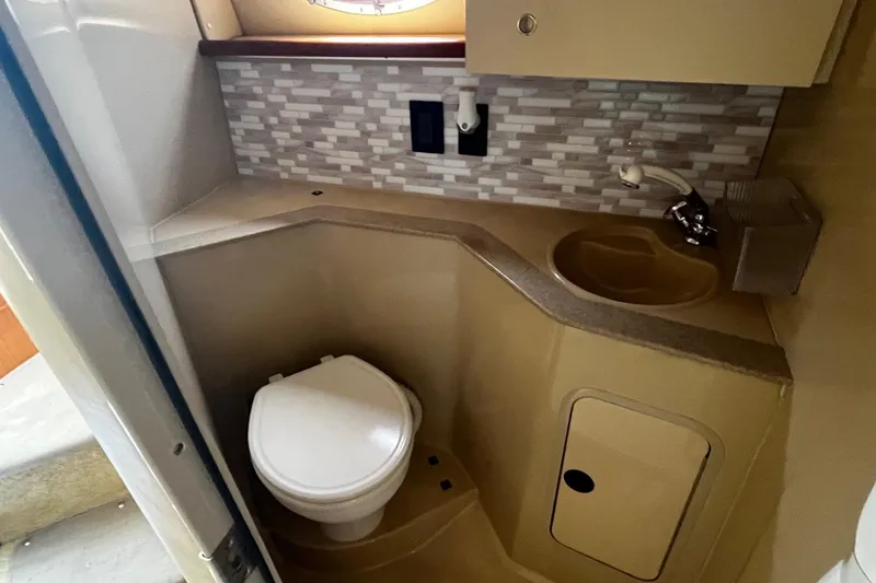 Slide: The Image of 2004 Cruisers Yachts 280 CXi Express bathroom with sink, toilet, and tiled backsplash. - 23