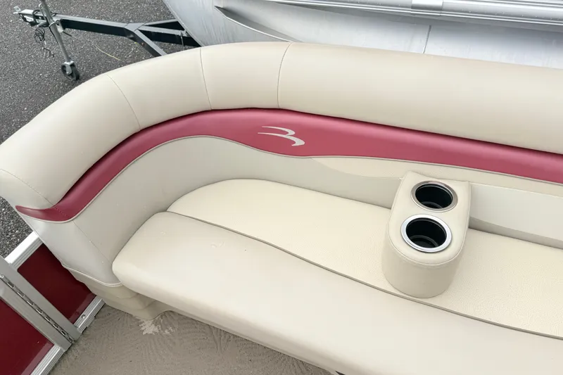 Slide: The Image of 2012 Bennington 20SLM boat seat with beige and maroon upholstery, featuring dual cup holders. - 9