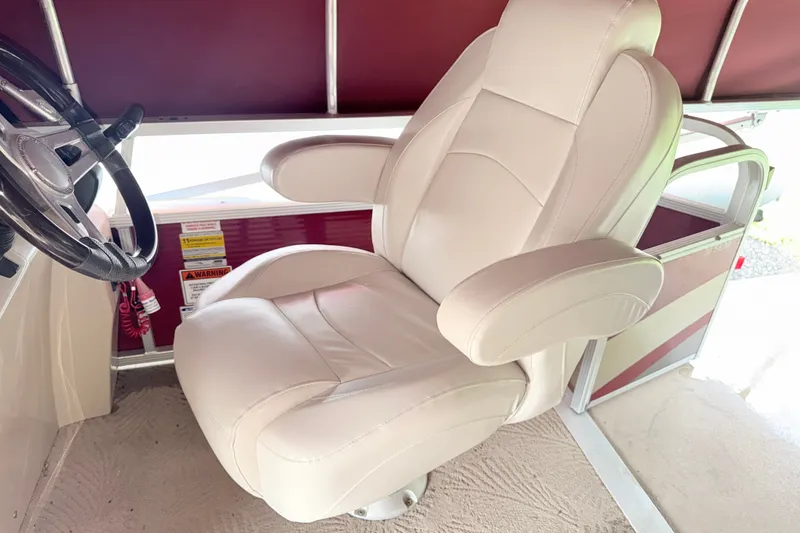Slide: The Image of Captain's chair on a 2012 Bennington 20SLM pontoon boat, featuring a sleek steering wheel. - 10