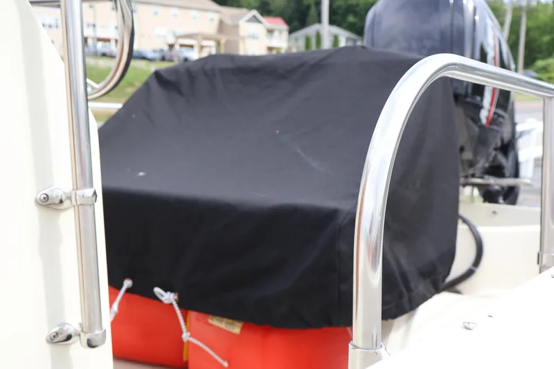 Slide: The Image of 1991 Boston Whaler 170 Montauk boat with covered console and visible outboard motor. - 28