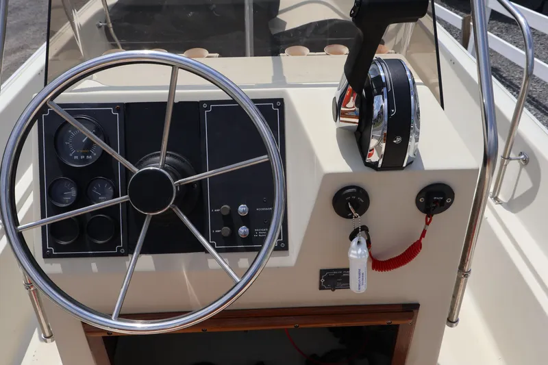 Slide: The Image of Steering console of a 1991 Boston Whaler 170 Montauk boat with controls and gauges. - 12