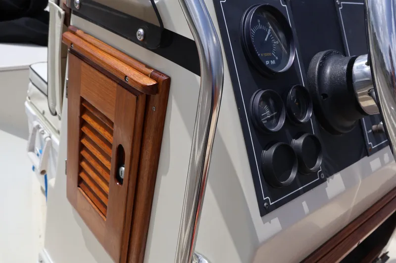 Slide: The Image of 1991 Boston Whaler 170 Montauk dashboard with gauges and wooden panel detail. - 14